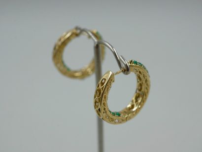 null Pair of 18k yellow gold hoop earrings set with emeralds in a diamond setting....