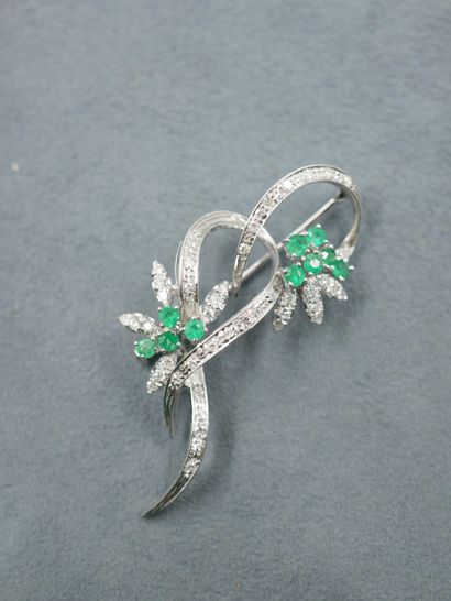 null Brooch in 18k white gold with flowers set with emeralds and diamonds. 

Work...
