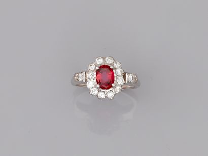 null 18k white gold ring centered with an oval ruby in a diamond setting.

PB : 4,70gr....