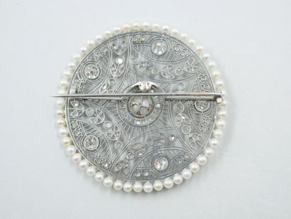 null 
Platinum circular pendant brooch in the garland style with a flowery lace pattern...