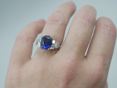 null 18k white gold ring set with a 4.50ct sapphire and cushion and baguette cut...