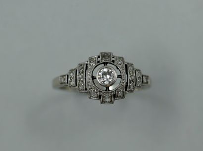 null Platinum ring topped by a diamond in an openwork setting set with small diamonds.

Period...
