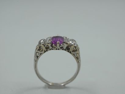 null 18k white gold ring centered on an oval pink sapphire surrounded by two lines...