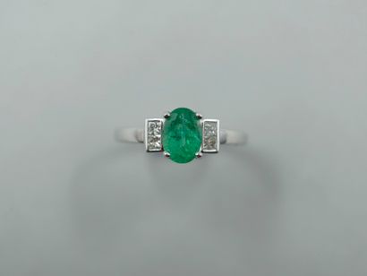 null 18k white gold ring set with a 1ct oval emerald and two princess cut diamonds....