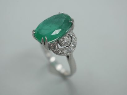 null 18k white gold ring set with an emerald of about 5 cts. and diamonds in an openwork...