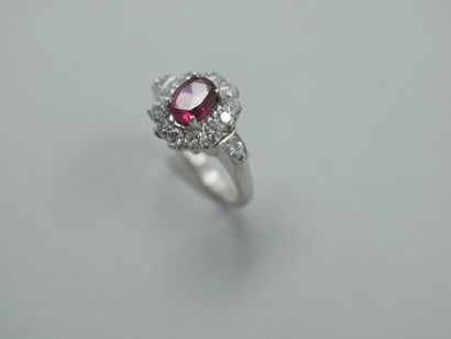 null 18k white gold ring centered with an oval ruby in a diamond setting.

PB : 4,70gr....