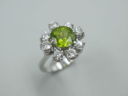null 18k white gold flower ring set with a 3ct peridot in a setting of eight diamonds....