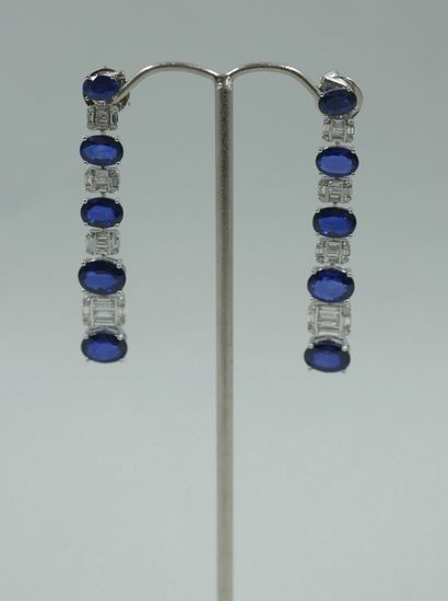null Pair of 18k white gold earrings set with five falling oval sapphires for about...