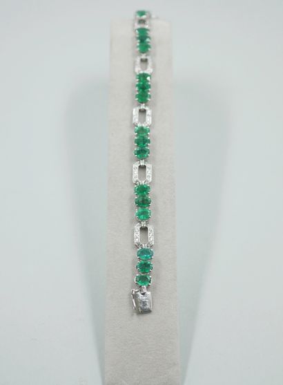 null 18k white gold line bracelet set with 18 oval emeralds weighing 14cts in total,...