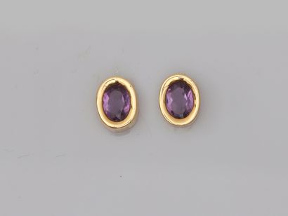 null 
Pair of 18k yellow gold earrings set with oval amethysts in a closed setting....