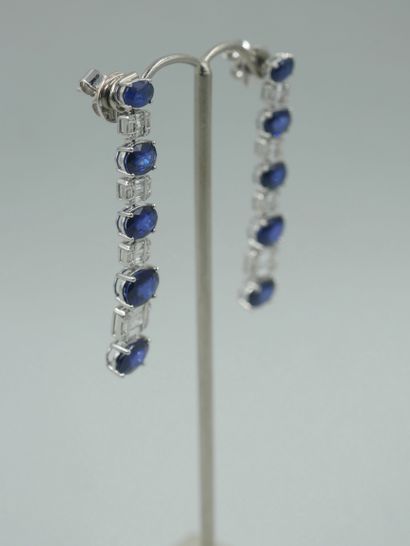 null Pair of 18k white gold earrings set with five falling oval sapphires for about...