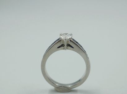 null 18k white gold ring set with a pear-cut diamond of 0.70cts on a line of calibrated...