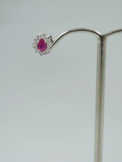 null A pair of 18k white gold earrings set with a pear-cut ruby in a diamond setting....