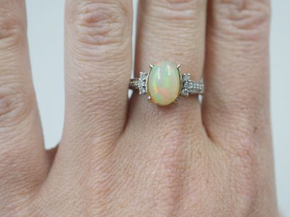 null 18k white gold ring set with an opal and diamonds. The setting partially paved...
