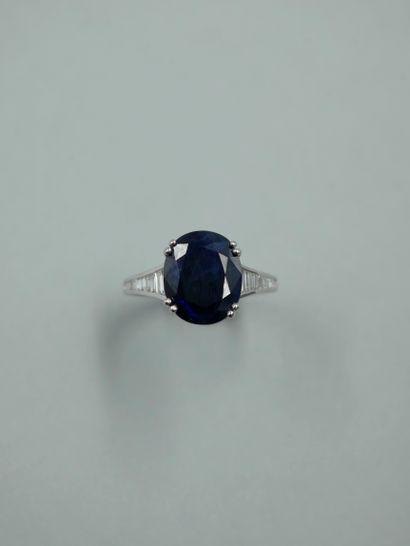 null Ring in 18k white gold set with an oval sapphire of 7.50cts and baguette-cut...