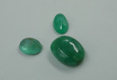 null Two oval emeralds on paper. 

With an emerald root bead.