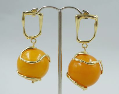 null 
Pair of 18k yellow gold earrings with imitation amber balls set in an irregular...