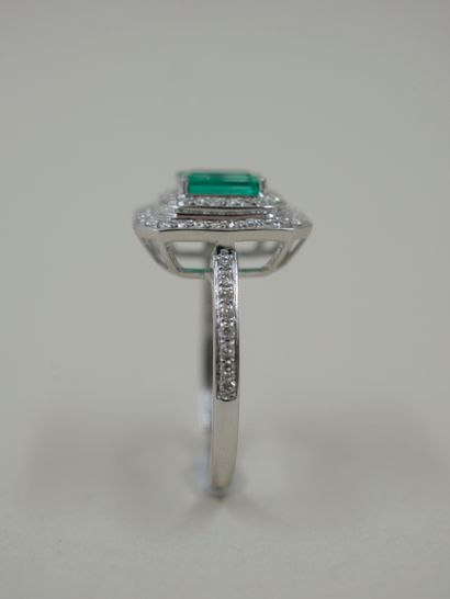 null 18k white gold rectangular cut ring set with a rectangular emerald weighing...