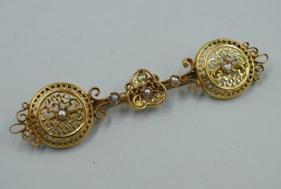 null Brooch in 18k yellow gold with openwork decoration of interlacing, punctuated...