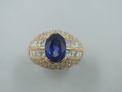 null 18k yellow gold dome ring centered on an oval sapphire of about 3.50cts, flanked...
