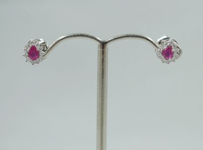 null A pair of 18k white gold earrings set with a pear-cut ruby in a diamond setting....