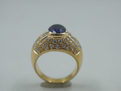 null 18k yellow gold dome ring centered on an oval sapphire of about 3.50cts, flanked...