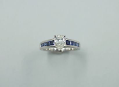 null 18k white gold ring set with a pear-cut diamond of 0.70cts on a line of calibrated...