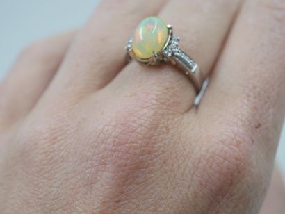 null 18k white gold ring set with an opal and diamonds. The setting partially paved...