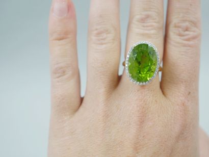 null 18k yellow gold ring surmounted by an oval peridot of about 12cts surrounded...