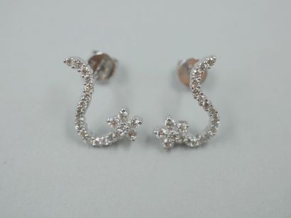 null Pair of earrings in 18k white gold with flower motifs underlined by a line of...