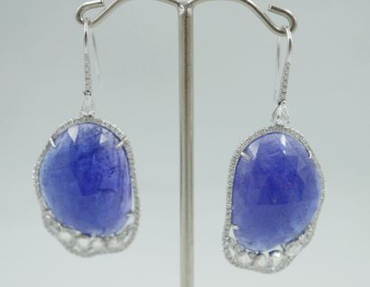 null Pair of 18k white gold earrings set with a large faceted tanzanite highlighted...