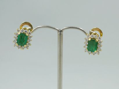null Pair of 18k yellow gold earrings set with an emerald cut emerald in a diamond...