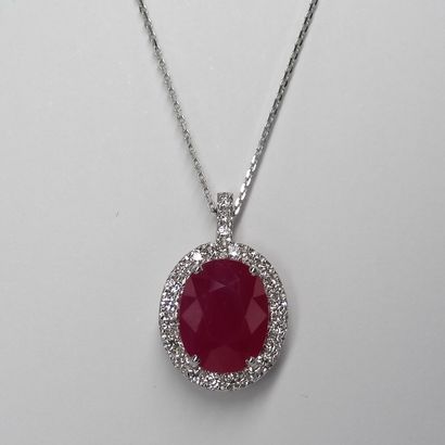 null 18k white gold pendant topped with an oval ruby of about 4.50cts surrounded...