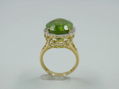null 18k yellow gold ring surmounted by an oval peridot of about 12cts surrounded...
