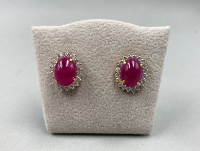 null Pair of 18k gold earrings each adorned with a cabochon of ruby in a diamond...