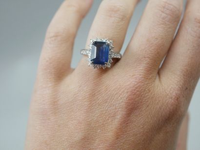 null Bague en platine ornée d'un saphir taille émeraude dans un entourage de diamants....