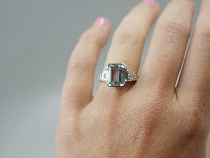 null 18k gold ring surmounted by an emerald-cut aquamarine of about 6 cts, with six...