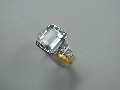 null 18k gold ring surmounted by an emerald-cut aquamarine of about 6 cts, with six...
