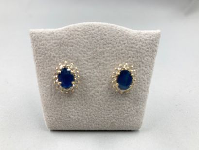 null Earrings in 18k yellow gold, each centered with a sapphire in claw setting in...