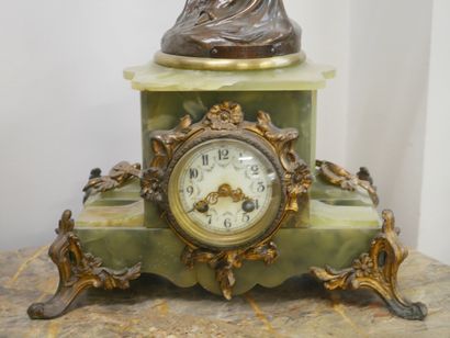 null Green onyx clock decorated with a bronze sculpture of a draped woman. 

ART...