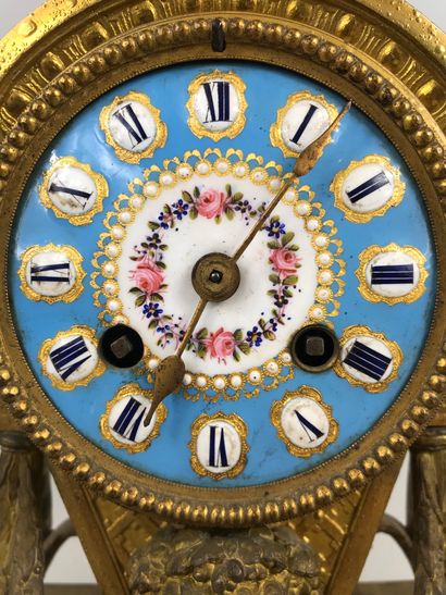null Clock in gilt bronze, the blue enamelled dial in the taste of Sevres. Surmounted...