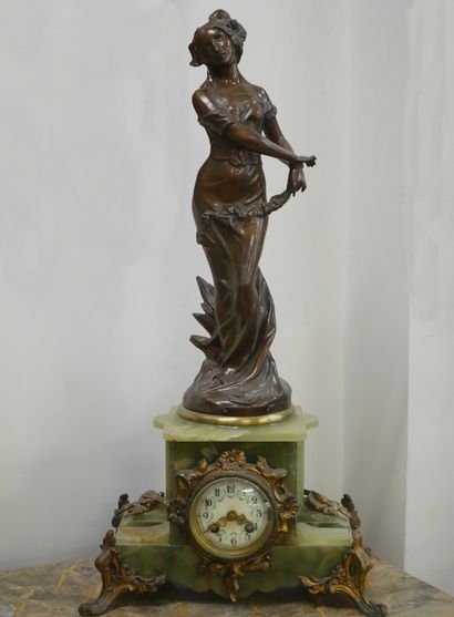 null Green onyx clock decorated with a bronze sculpture of a draped woman. 

ART...