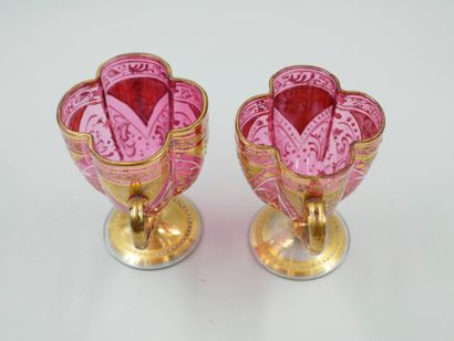 null Pair of red glass cups with gilded decoration of interlacing, with saucers.
