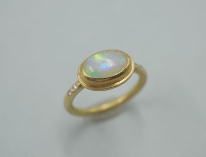 null 
Bague en or jaune 18k ornée d'un cabochon d'opale accosté de petites pierres...