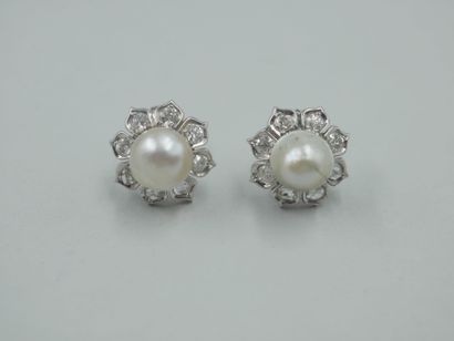 null 
Paire de boucles d'oreille fleurs en or gris 18k, chacune centrée d'une perle...