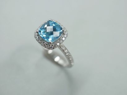 null 18k white gold ring set with a faceted cushion-cut blue topaz in a diamond setting....