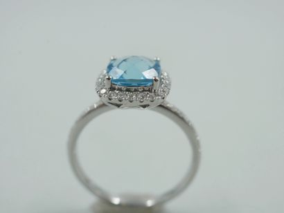 null 18k white gold ring set with a faceted cushion-cut blue topaz in a diamond setting....