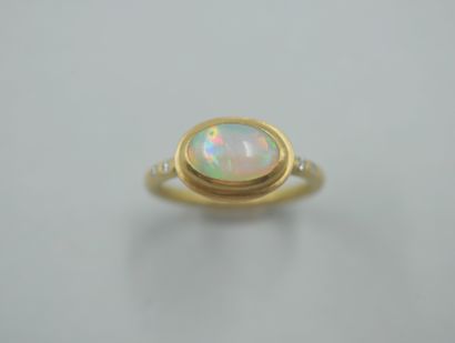 null 
Bague en or jaune 18k ornée d'un cabochon d'opale accosté de petites pierres...