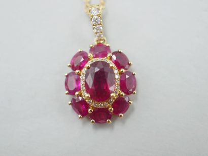 null Flower pendant in 18k yellow gold set in its center with an oval ruby of about...