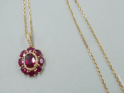 null Flower pendant in 18k yellow gold set in its center with an oval ruby of about...